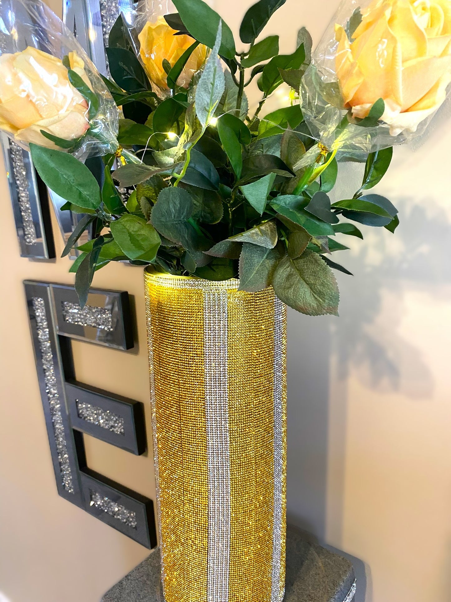 Vibrant Gold V-Style Crystal Rhinestone Cylinder Vase is 15" tall. Long-stem silk floral arrangement sold separately.