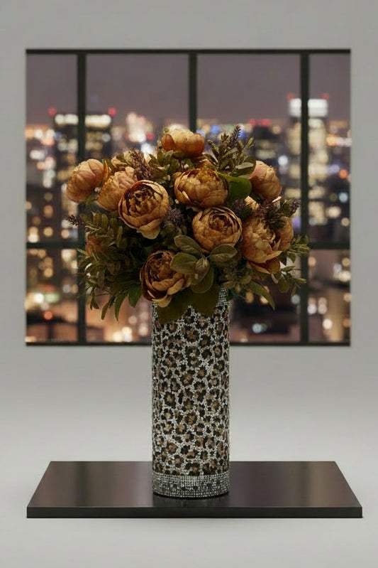 Decorative floral arrangement in a leopard print vase on a kitchen counter.