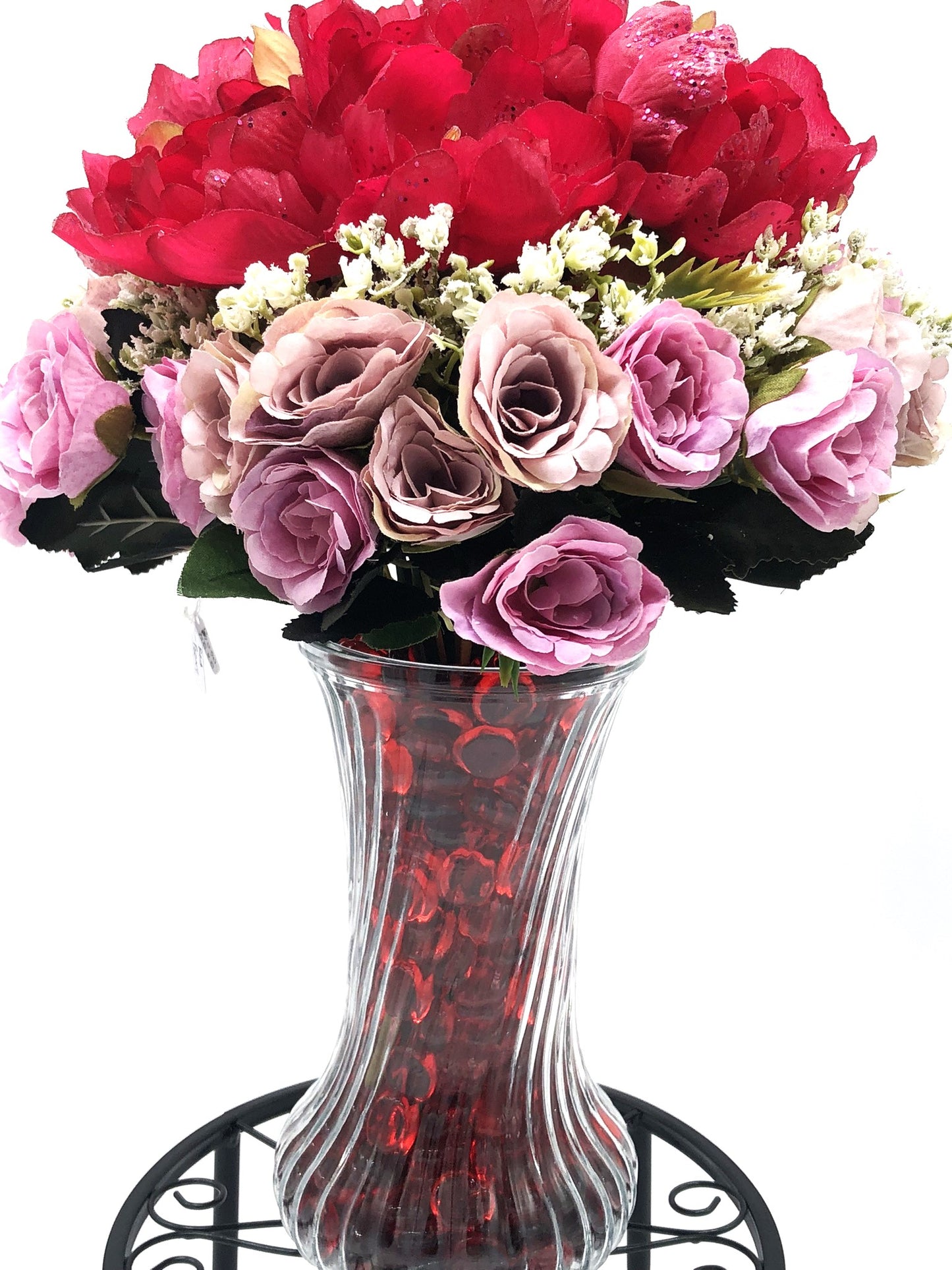 Red/Purple Passion Silk Floral Arrangement with baby's breath in glass-swirl vase filled with red translucent gems.
